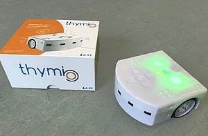 Der mobile Lernroboter Thymio II und daneben die Originalverpackung